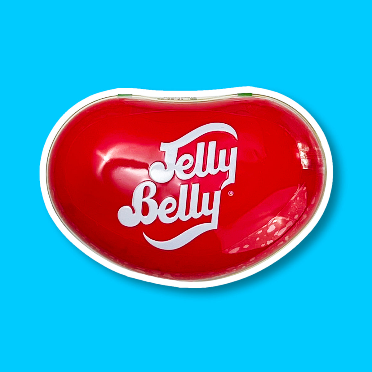 Une grande boite rouge en forme d’haricots avec écrit en blanc « Jelly Belly ». Le tout sur fond bleu