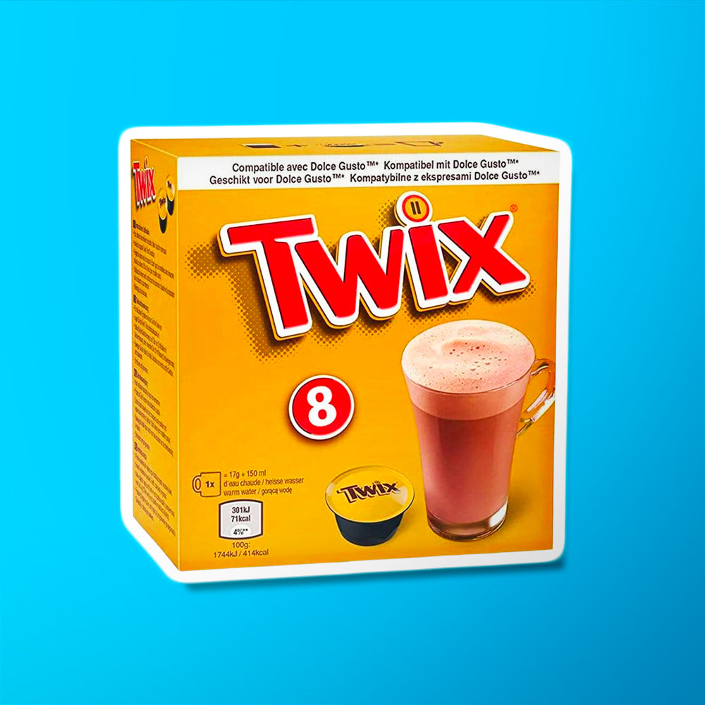 Un carton doré sur fond bleu avec écrit en grand « Twix » en rouge. Sur le devant, il y a une capsule Twix noir et doré et à droite une grande tasse transparente avec du chocolat chaud