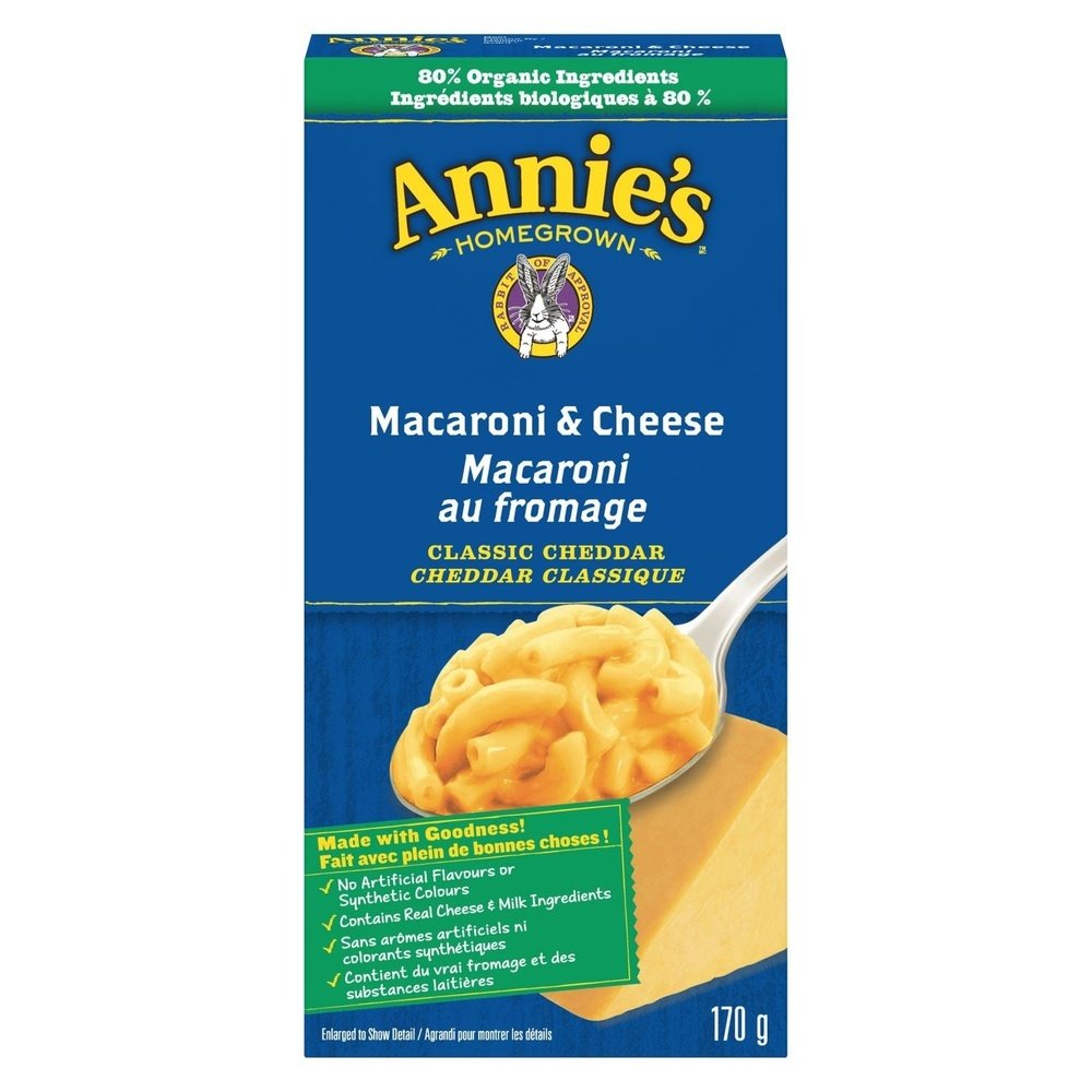 Un paquet bleu sur fond blanc avec au centre une cuillère de Mac&Cheese crémeux et à l’arrière un morceau de fromage