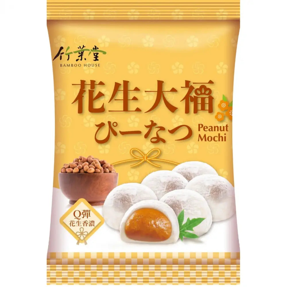 Un emballage orangé sur fond blanc avec 6 mochis blancs dont un qui est coupé avec un intérieur orange. A gauche, un bol en bois rempli d’arachides