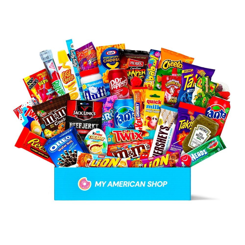 Un très grand carton rectangulaire bleu sur fond blanc contenant plein de snacks américains sucrés et salés comme des Reese’s, Lion, Takis, Quick Milk vanilla, Dr Pepper, Laffy Taffy, …