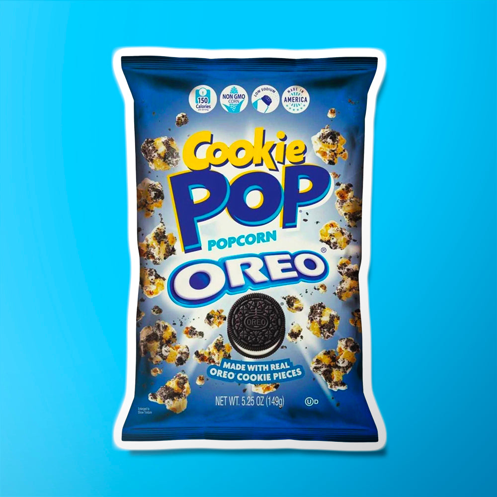 Un paquet bleu sur fond bleu avec plein de popcorn au chocolat et un biscuit noir fourré à la crème blanche