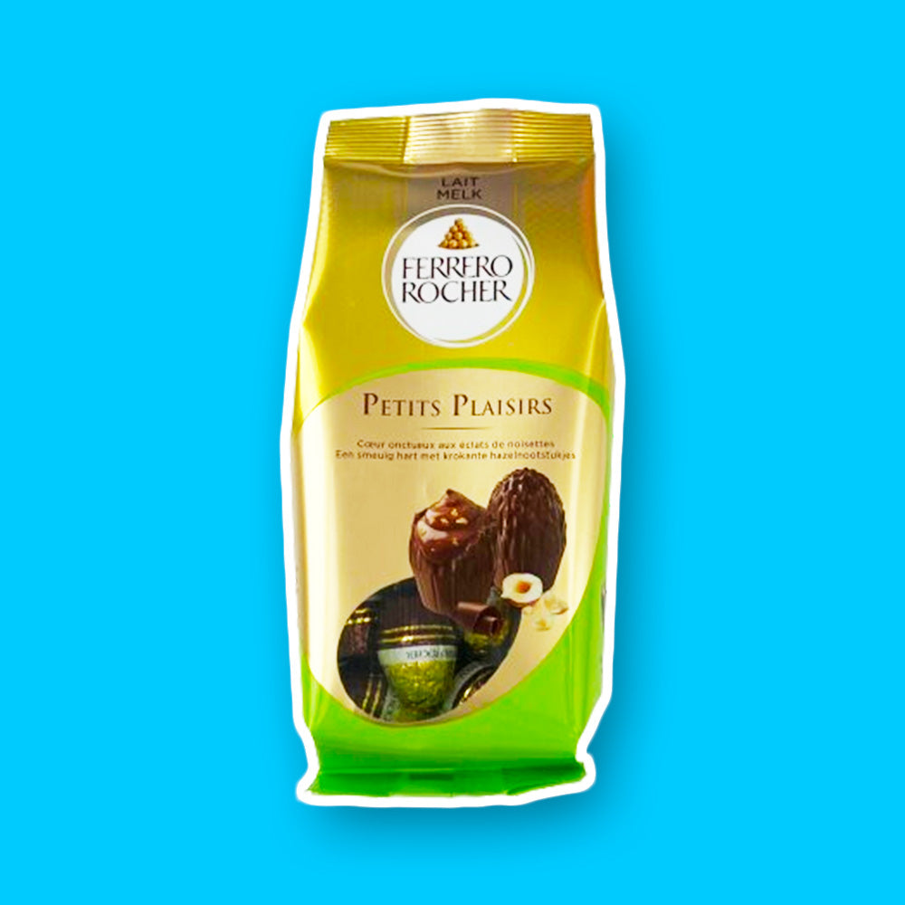 Un paquet jaune et vert avec au milieu des Ferrero Rocher brun et des noisettes à côté. Le tout sur fond bleu