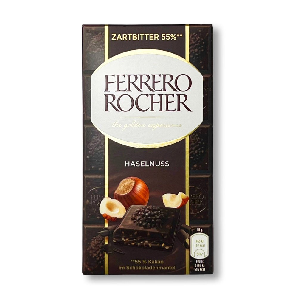 Un emballage de la couleur du chocolat noir avec un carré au chocolat noir et derrière une noisette entière et 2 éclats de part et d’autre. Le tout sur fond blanc