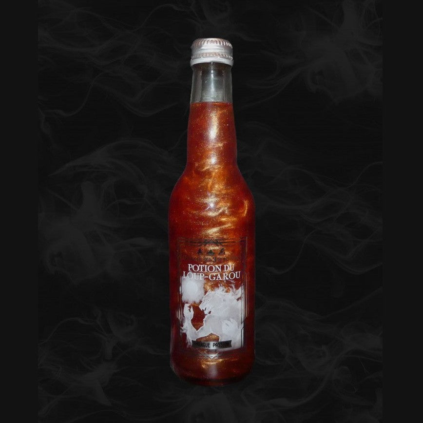 Une bouteille transparente avec une boisson pailletée orange et sur l’étiquette un loup-garou blanc. Le tout sur fond noir avec de la fumée