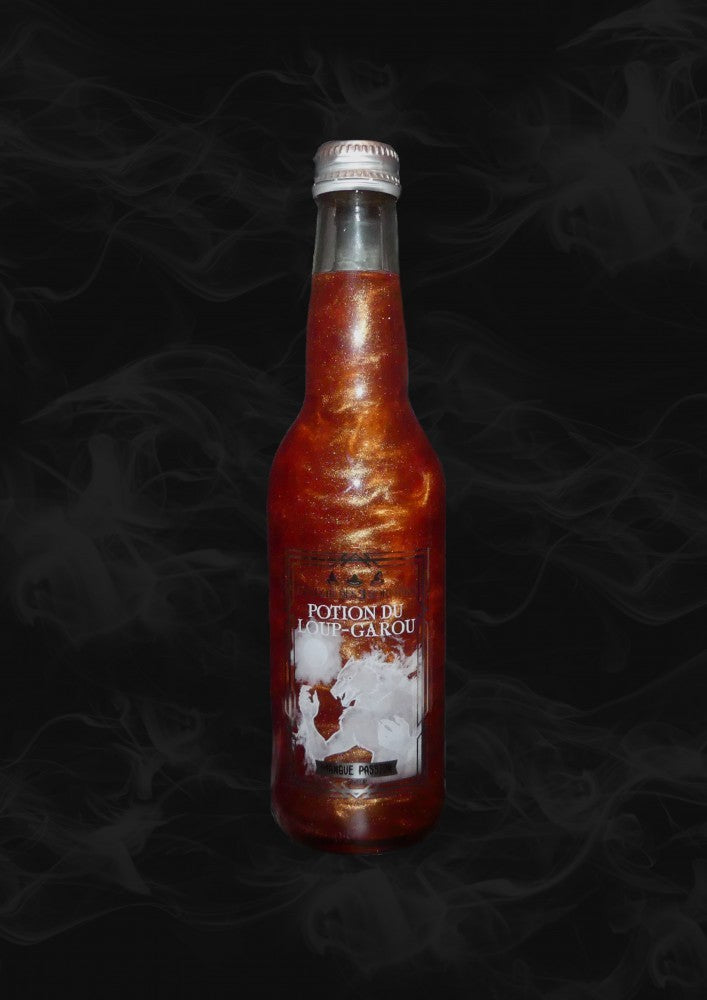 Une bouteille transparente avec une boisson pailletée orange et sur l’étiquette un loup-garou blanc. Le tout sur fond noir avec de la fumée