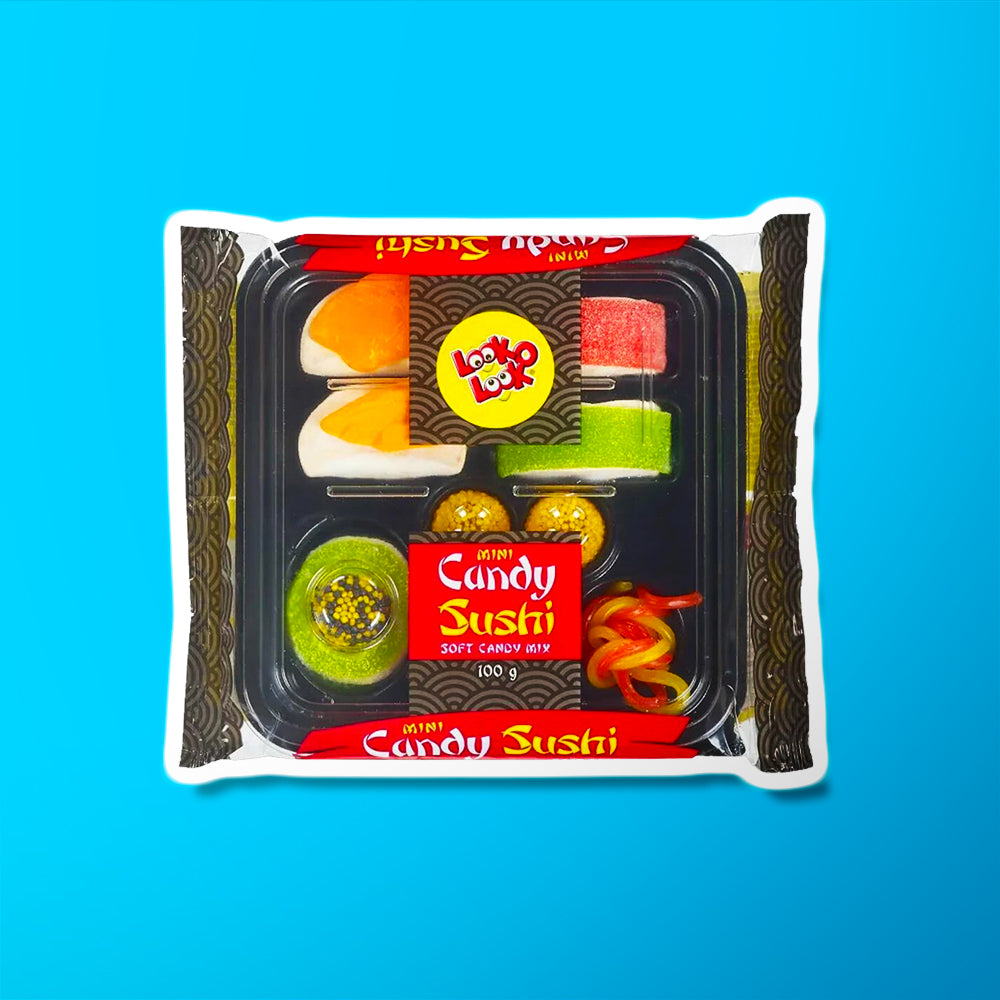 Un emballage transparent où il y a un plateau noir avec des bonbons en forme de sushis, makis et nouilles. Le tout sur fond bleu