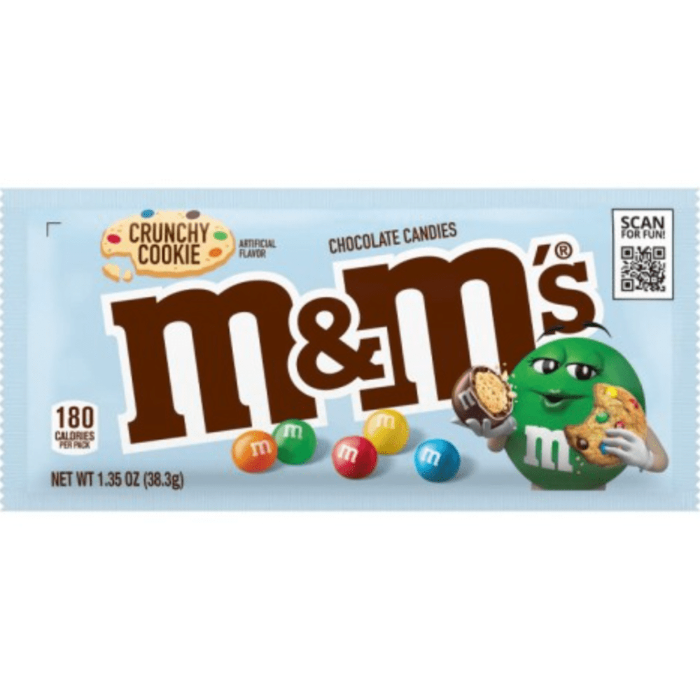 Un paquet bleu sur fond blanc avec un bonhomme M&M’s vert qui tient un cookie et un m&m’s marrons et sur le côté gauche il y a d’autres m&m’s colorés