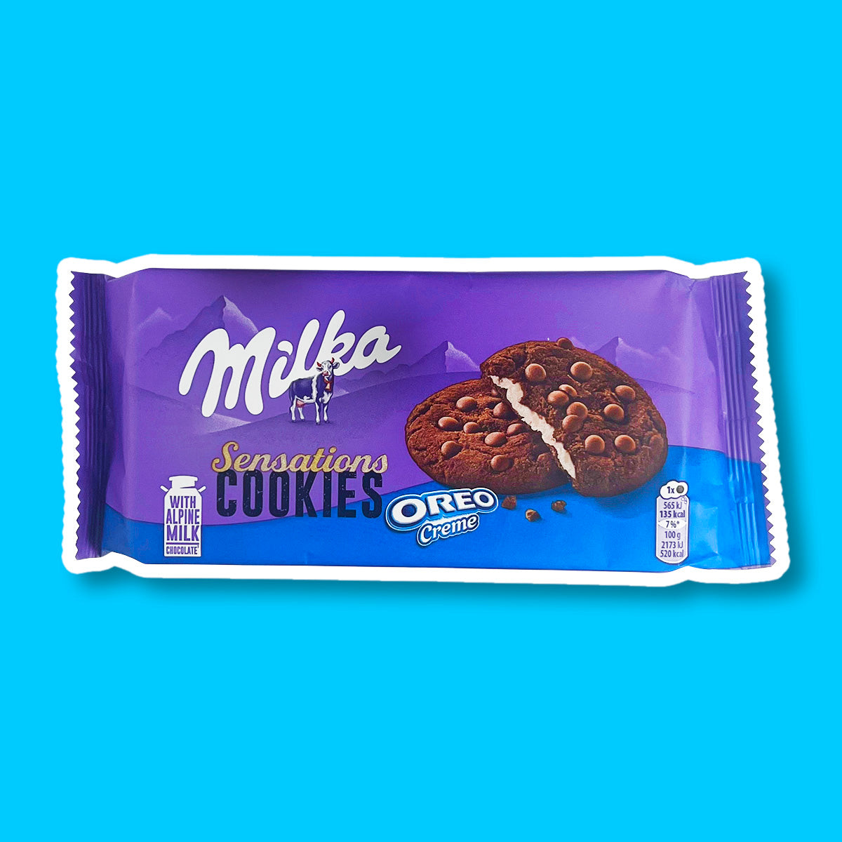 Un emballage mauve en haut et bleu au-dessus avec 2 cookies marrons fourrés avec une crème blanche et des pépites de chocolat a-dessus, le tout sur fond bleu