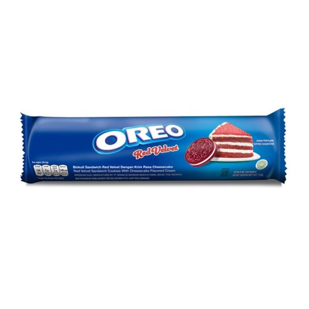 Un emballage long bleu sur fond blanc avec une part de gâteau rouge sur une assiette blanche et à côté un biscuit rouge