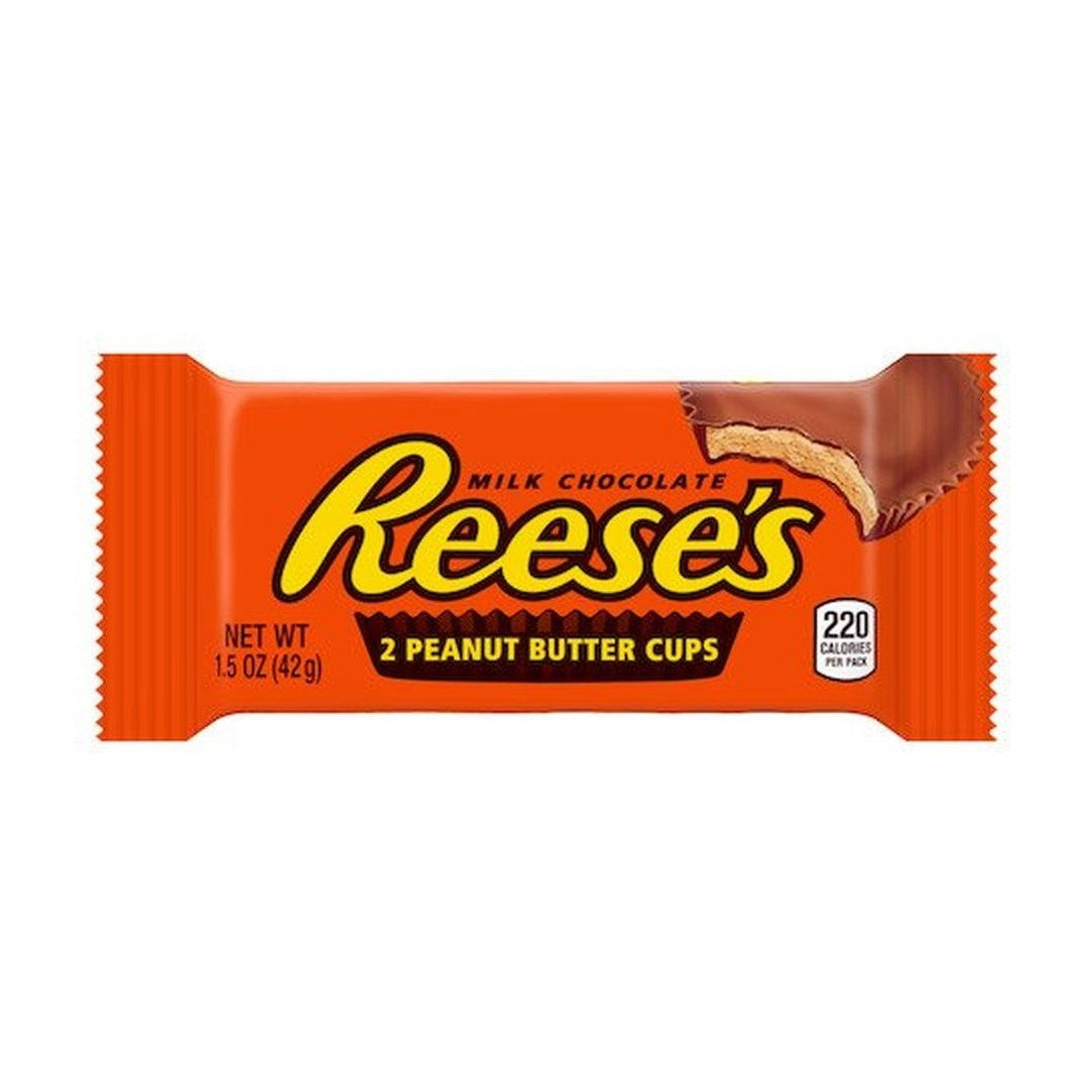 Un emballage orange sur fond blanc avec écrit « Reese’s » au centre et au milieu, au-dessus à droite il y a un chocolat en cup qui est croqué et on y voit une pâte brune claire