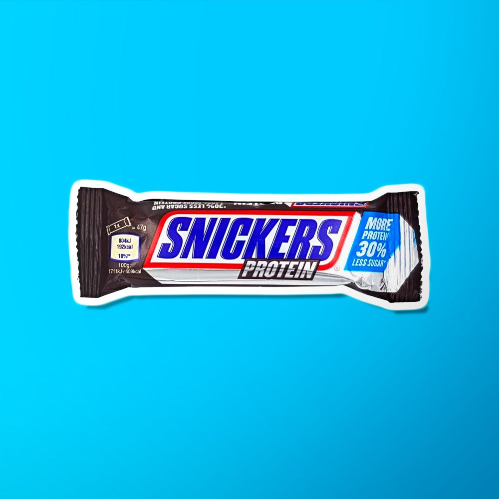 Un emballage marron foncé sur fond bleu avec au centre écrit « Snickers » en bleu et en bas il est écrit « Protein »