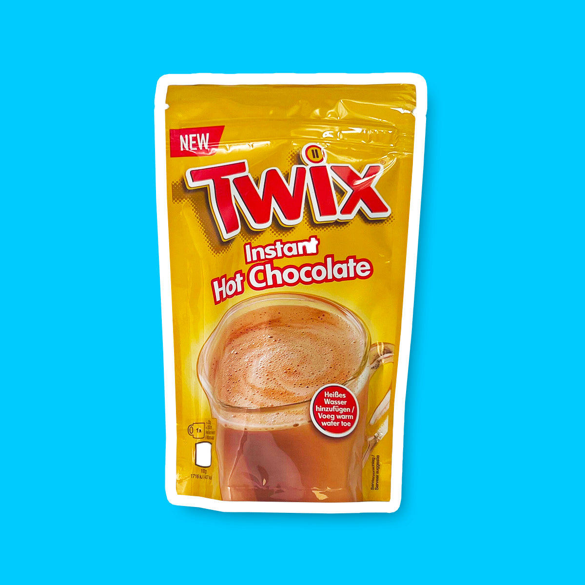 Un emballage doré sur fond bleu avec une tasse transparente de chocolat chaud avec écrit en grand « Twix » en rouge 