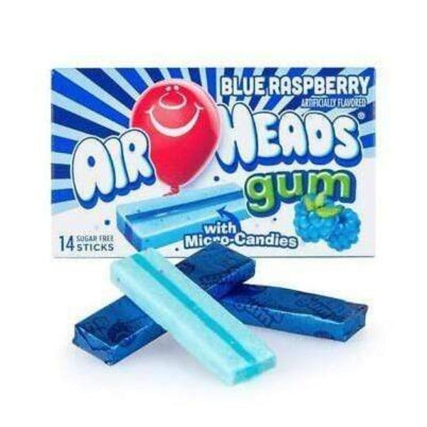 Un paquet bleu sur fond blanc avec un ballon rouge qui sourit et il y a un chewing-gum bleu et à droite une framboise bleue. Devant il y a 3 bonbons bleus dont un déballé