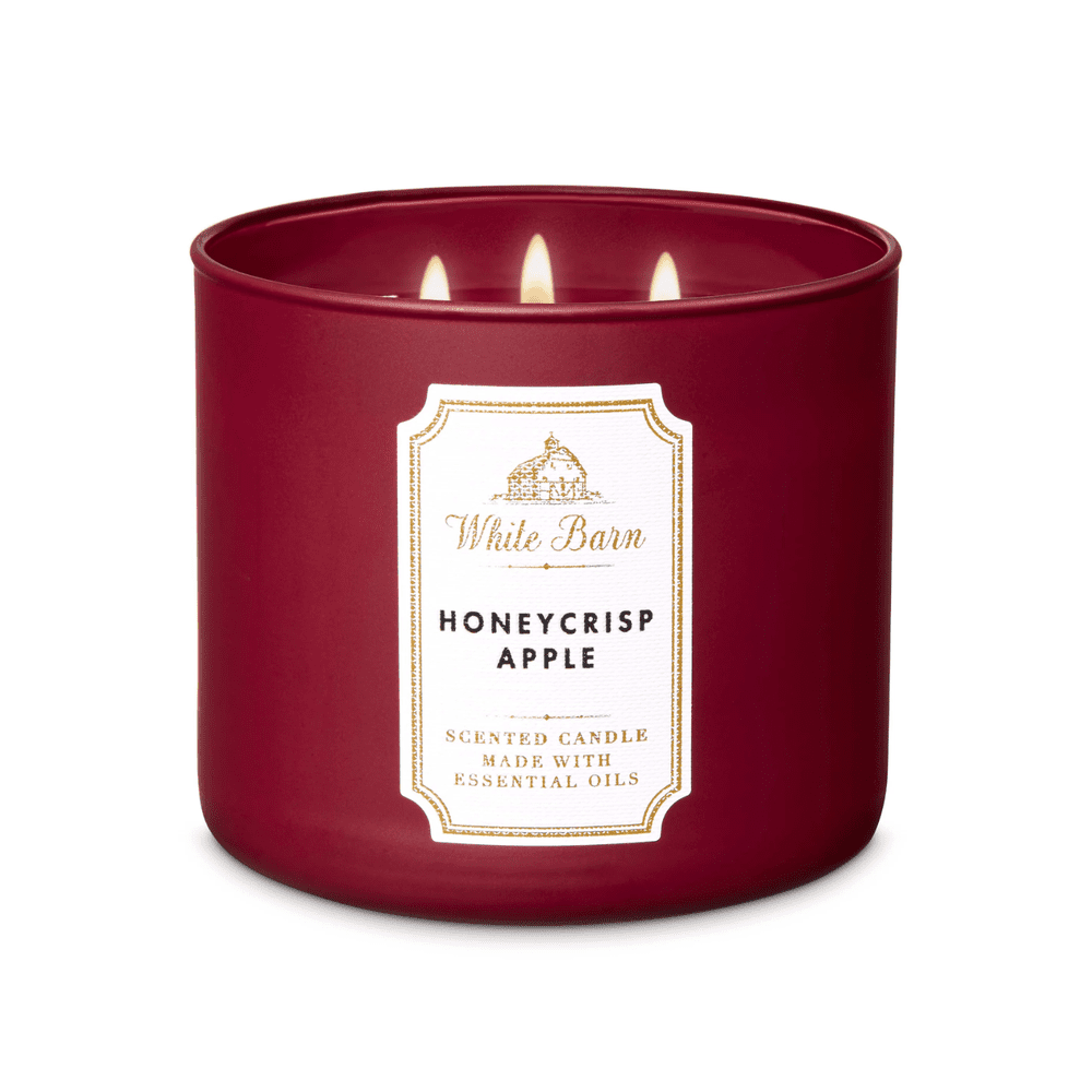 Un contenant en verre bordeaux sur fond blanc avec une étiquette blanche encadrée de doré