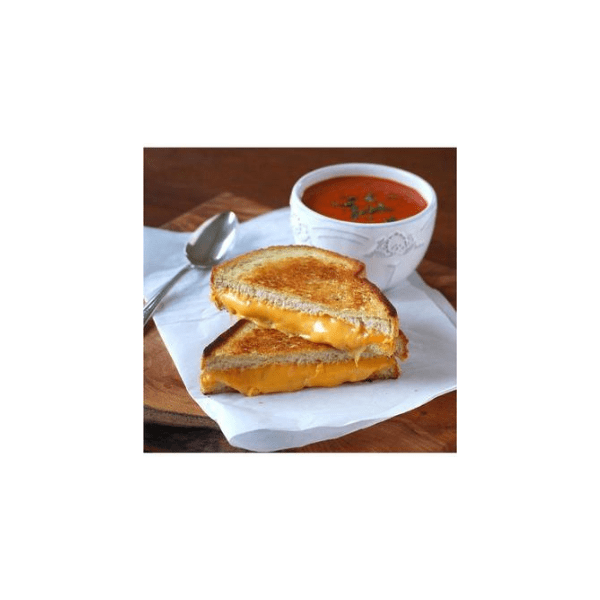 Un pain au fromage toasté et une tasse blanche avec une soupe à la tomate rouge sur une serviette blanche et sur une table en bois