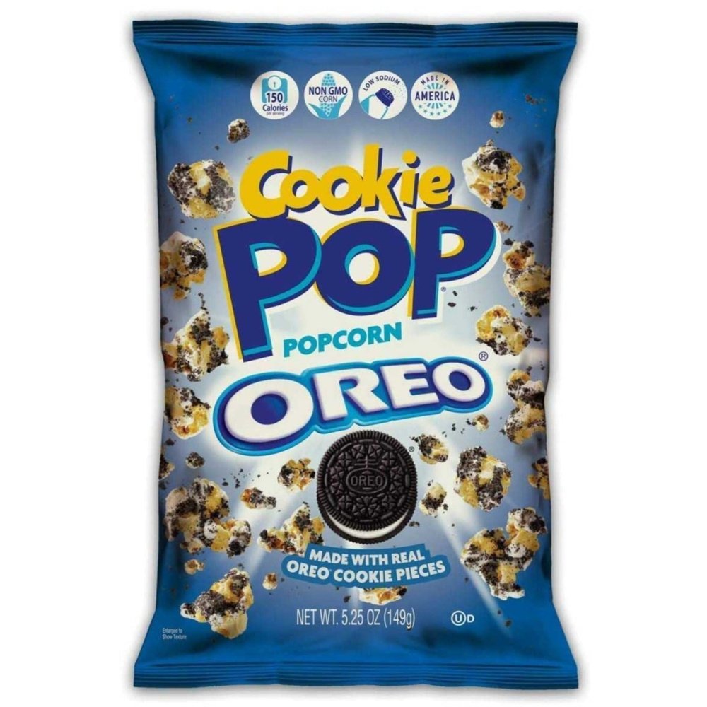 Un paquet bleu sur fond blanc avec plein de popcorn au chocolat et un biscuit noir fourré à la crème blanche