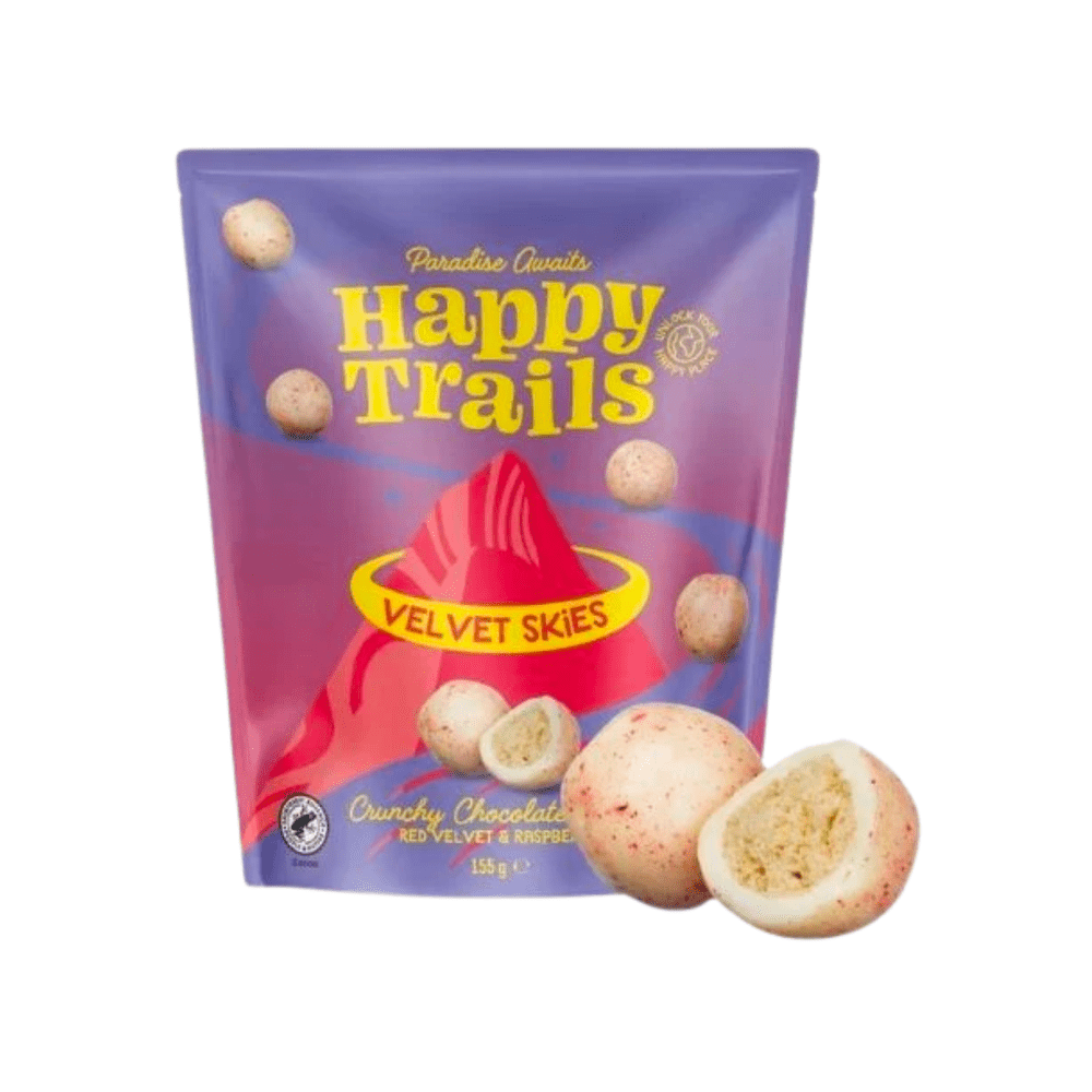 Un emballage rose-mauve sur fond blanc avec un paysage montagneux et plusieurs biscuits en forme de boule et au-dessus écrit en jaune « Happy Trails »