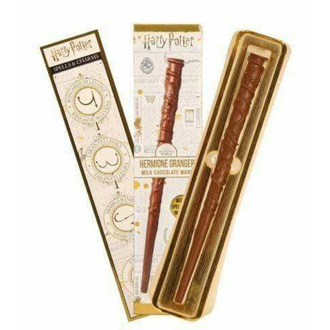 Un emballage ouvert sur fond blanc avec 3 parties, on y voit le chocolat en forme de baguette magique dans un compartiment doré