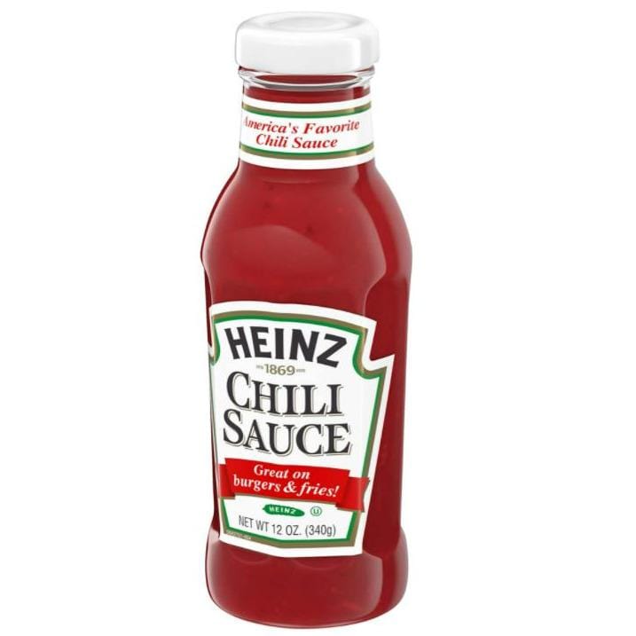 Une bouteille en verre transparent d’une sauce rouge, un capuchon blanc et une étiquette blanche au centre. Le tout sur fond blanc