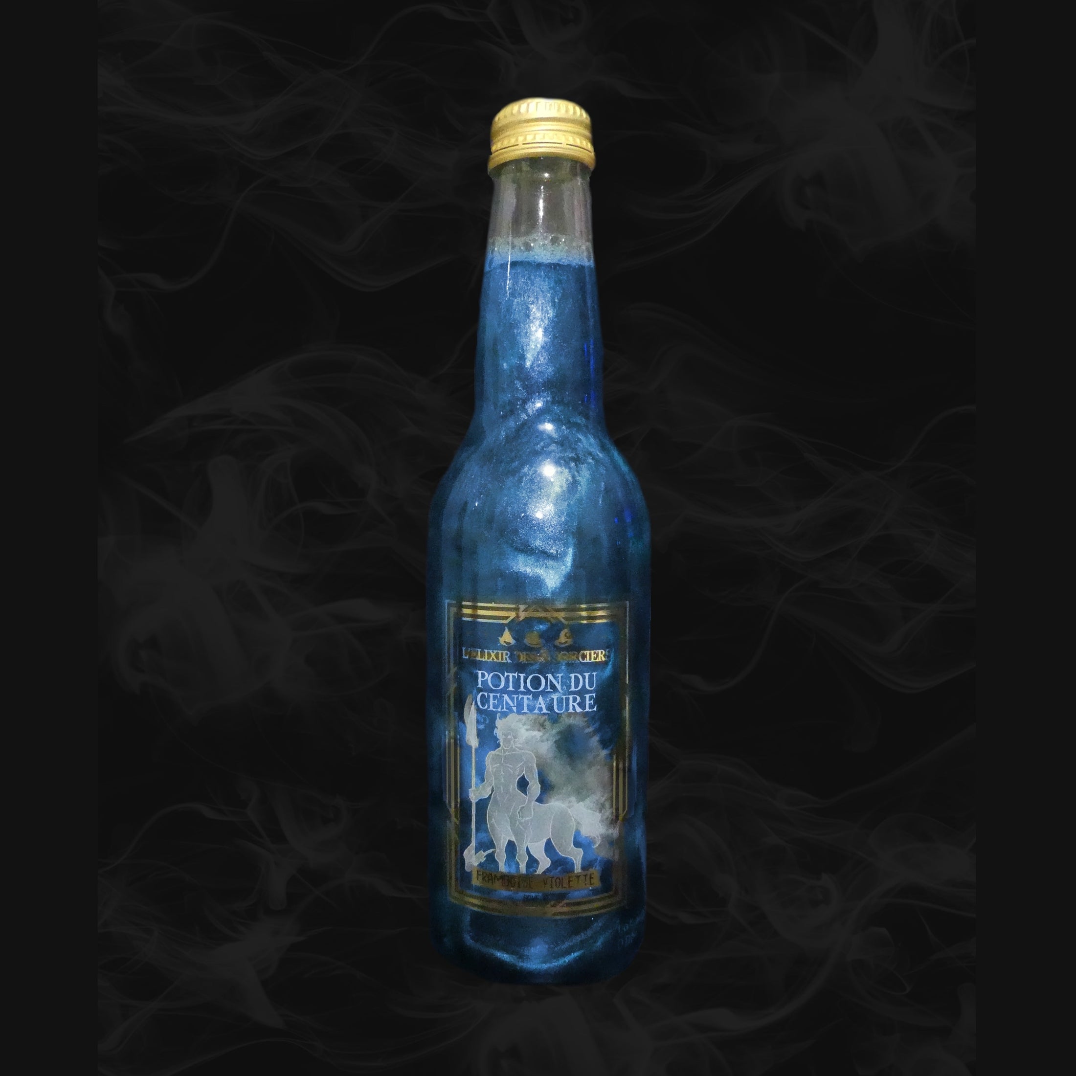 Une bouteille transparente avec une boisson pailletée bleue et sur l’étiquette une créature blanche mi-homme mi-cheval. Le tout sur fond noir avec de la fumée