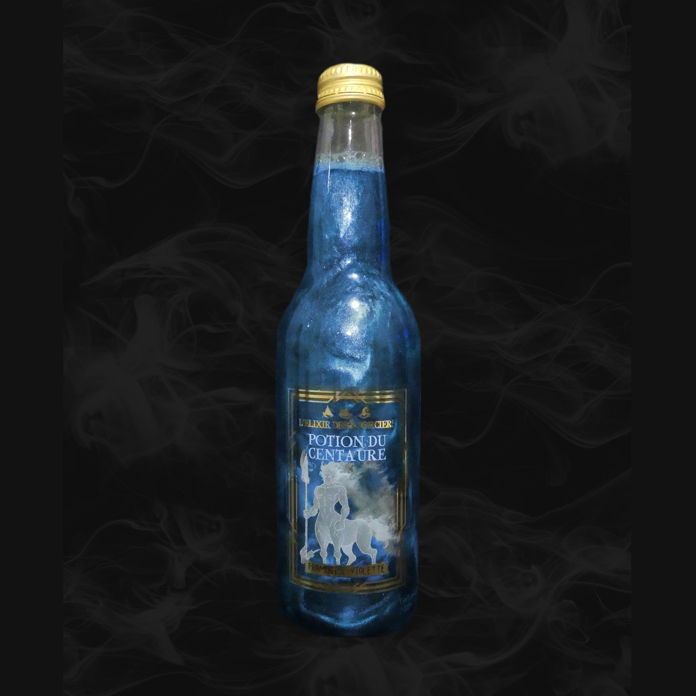 Une bouteille transparente avec une boisson pailletée bleue et sur l’étiquette une créature blanche mi-homme mi-cheval. Le tout sur fond noir avec de la fumée