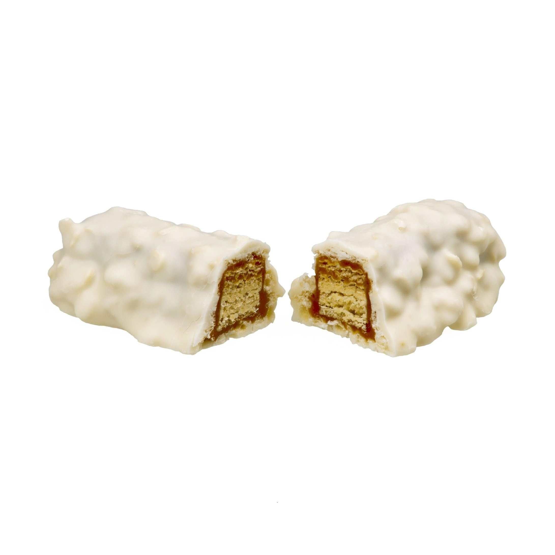 Une barre chocolatée au chocolat blanc coupée en 2 avec à l’intérieur du biscuits et du caramel, le tout sur fond blanc