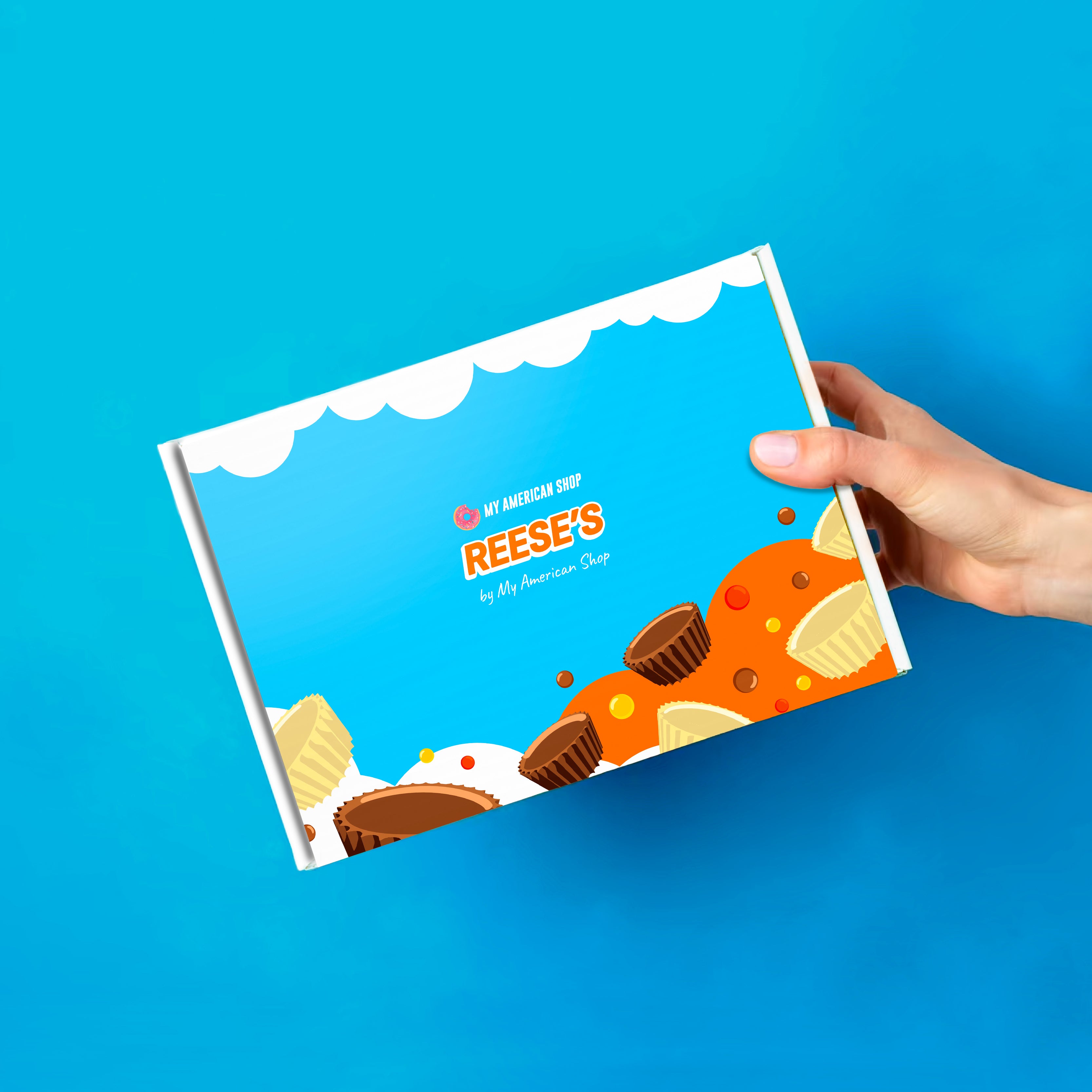 Un carton bleu et blanc avec des dessins de cups Reese’s chocolat au lait et chocolat blanc, le tout sur fond bleu