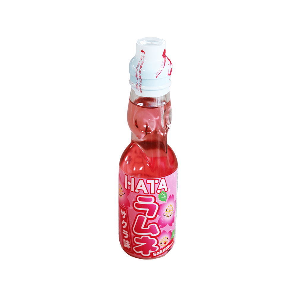 Une bouteille transparente sur fond blanc avec une boisson légèrement rosée, il y a une étiquette rose sur la moitié basse de la bouteille. Il y a des fleurs de cerisiers qui sourient