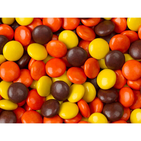 Un tas de petits bonbons ronds jaune, orange et brun