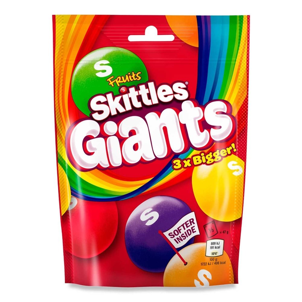 Un grand emballage rouge sur fond blanc avec un arc-en-ciel et 5 gros Skittles rouge, mauve, jaune, orange et vert